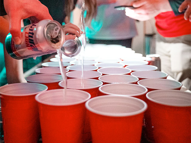 Adults playing drinking games with plastic solo cups