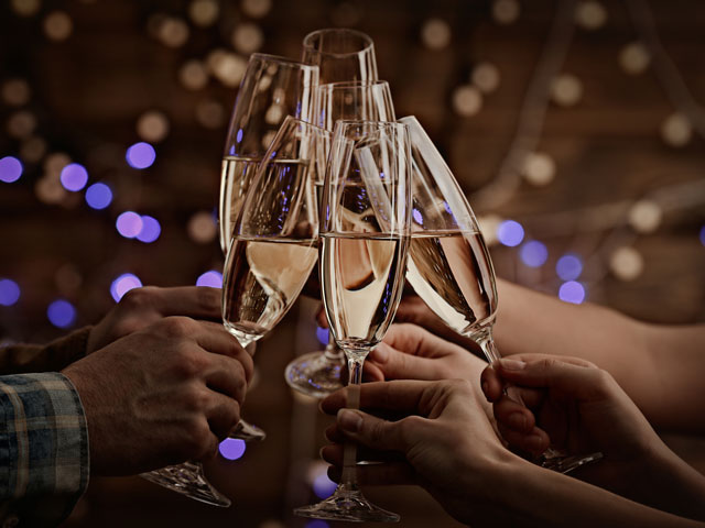 A group of people clinking champagne glasses together in toast