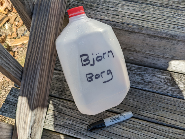 Using a black sharpie to name the empty gallon jug for a Black Out Rage Gallon