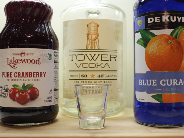 The ingredients to make a Purple Gatorade Shot, including Vodka, Blue Curacao and Cranberry Juice