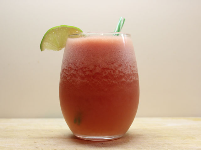 A Watermelon Daiquiri freshly made with a lime garnish and straw